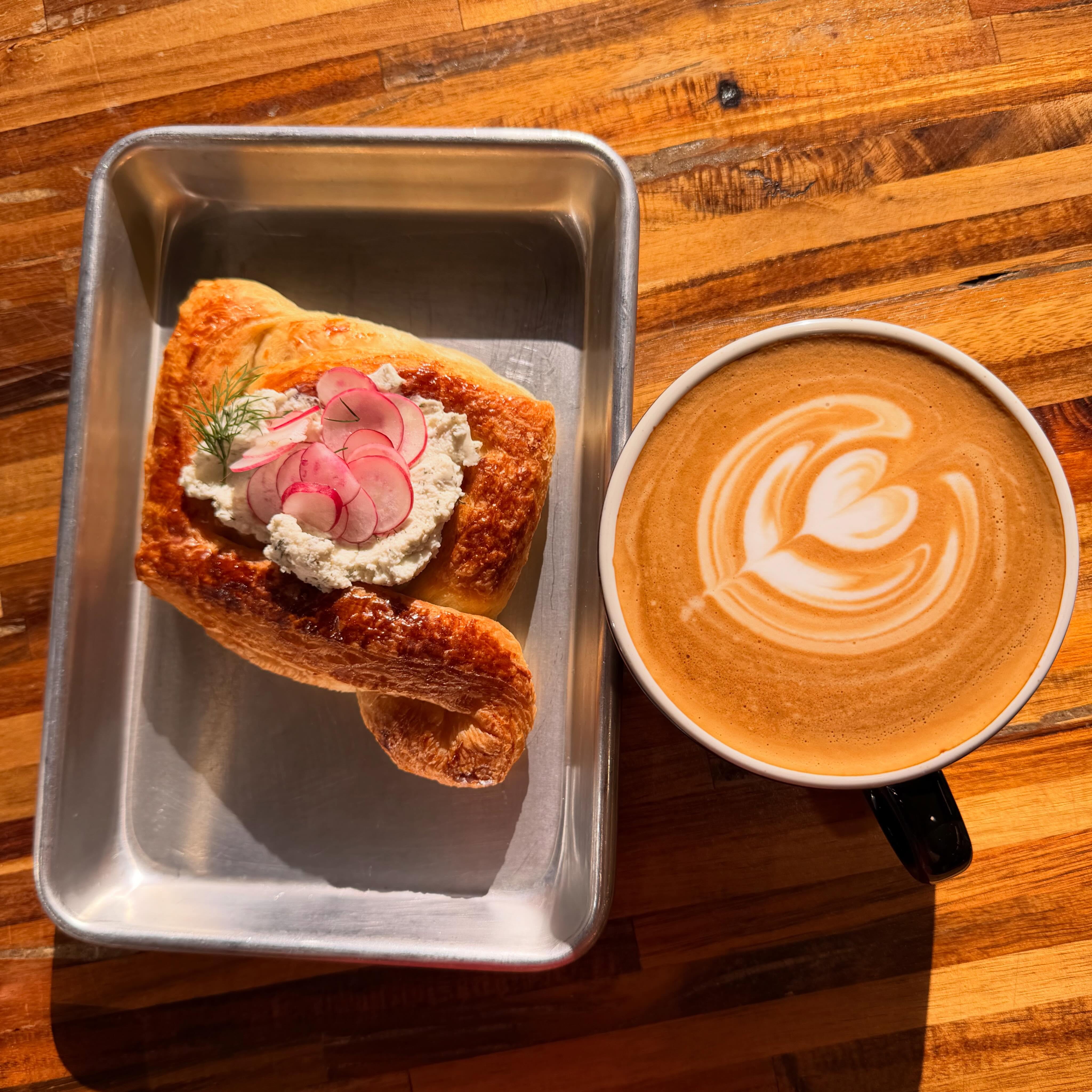 Herb ricotta relish croissant next to a latte